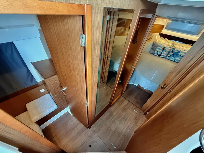 Remotely Workin' Yacht Photos Pics Interior of 2022 Jeanneau NC 1095 Coupe, featuring wood finishes and cozy cabin space.