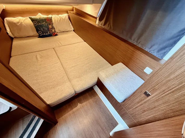 Remotely Workin' Yacht Photos Pics 2022 Jeanneau NC 1095 Coupe cabin with cozy bed and wooden interior.