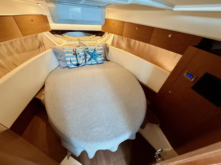 Remotely Workin' Yacht Photos Pics Cozy cabin interior of 2022 Jeanneau NC 1095 Coupe with nautical-themed pillows.