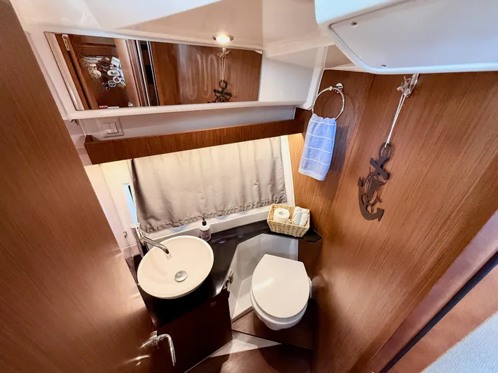 Remotely Workin' Yacht Photos Pics Bathroom interior of 2022 Jeanneau NC 1095 Coupe with modern fixtures and wooden accents.