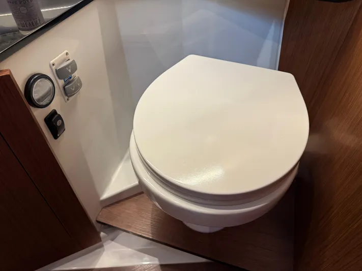 Remotely Workin' Yacht Photos Pics Toilet in 2022 Jeanneau NC 1095 Coupe boat, featuring modern design and wood accents.