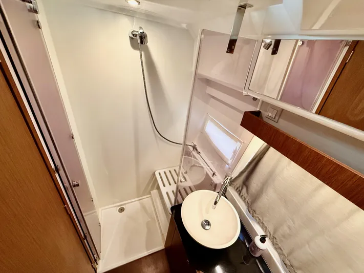 Remotely Workin' Yacht Photos Pics 2022 Jeanneau NC 1095 Coupe bathroom with shower, sink, and modern fixtures.