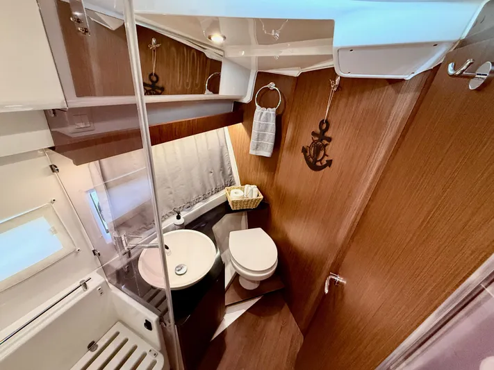 Remotely Workin' Yacht Photos Pics Bathroom interior of 2022 Jeanneau NC 1095 Coupe, featuring modern fixtures and wood accents.