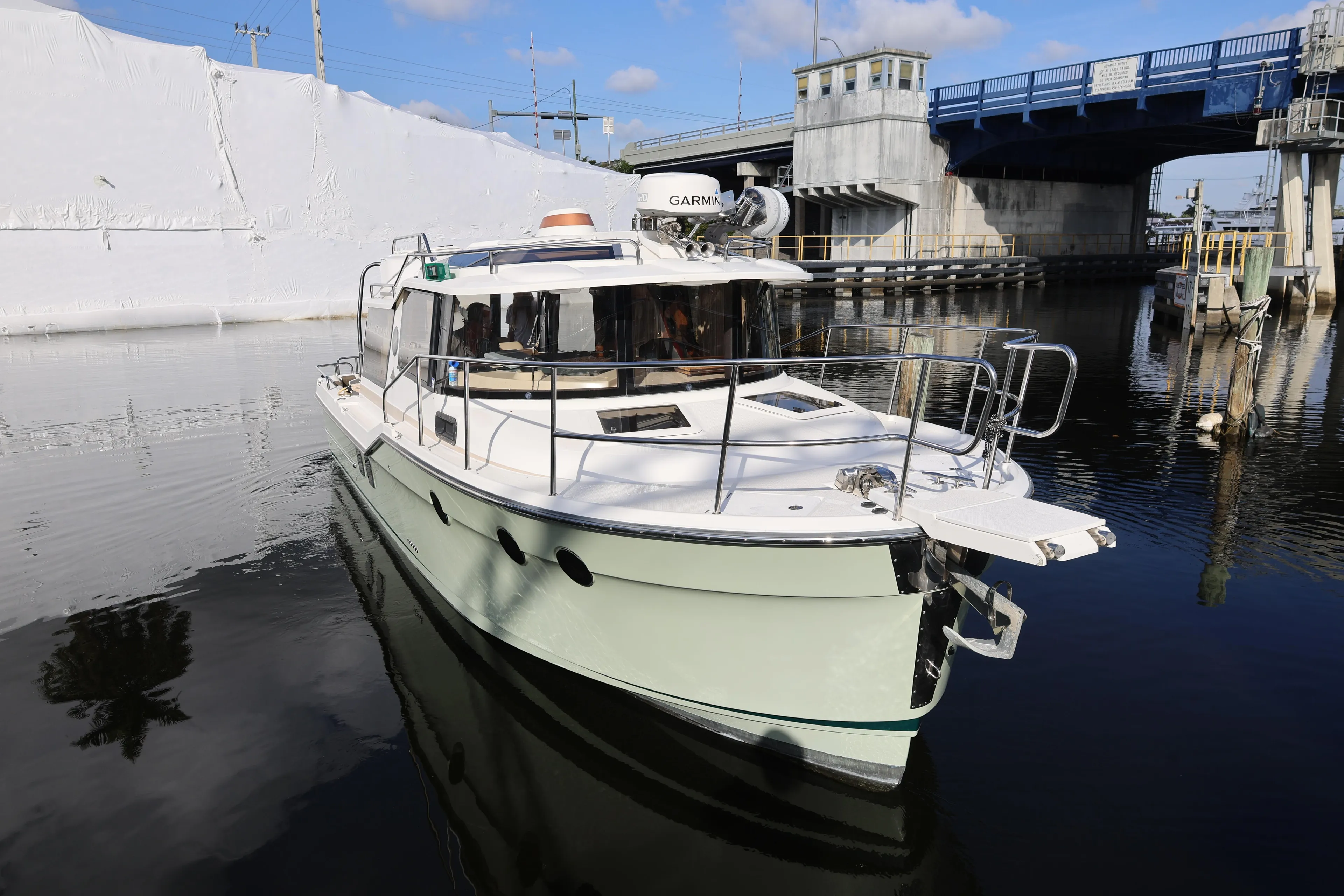 2015 Ranger Tugs R-29 S boat navigating near a bridge on a sunny day.