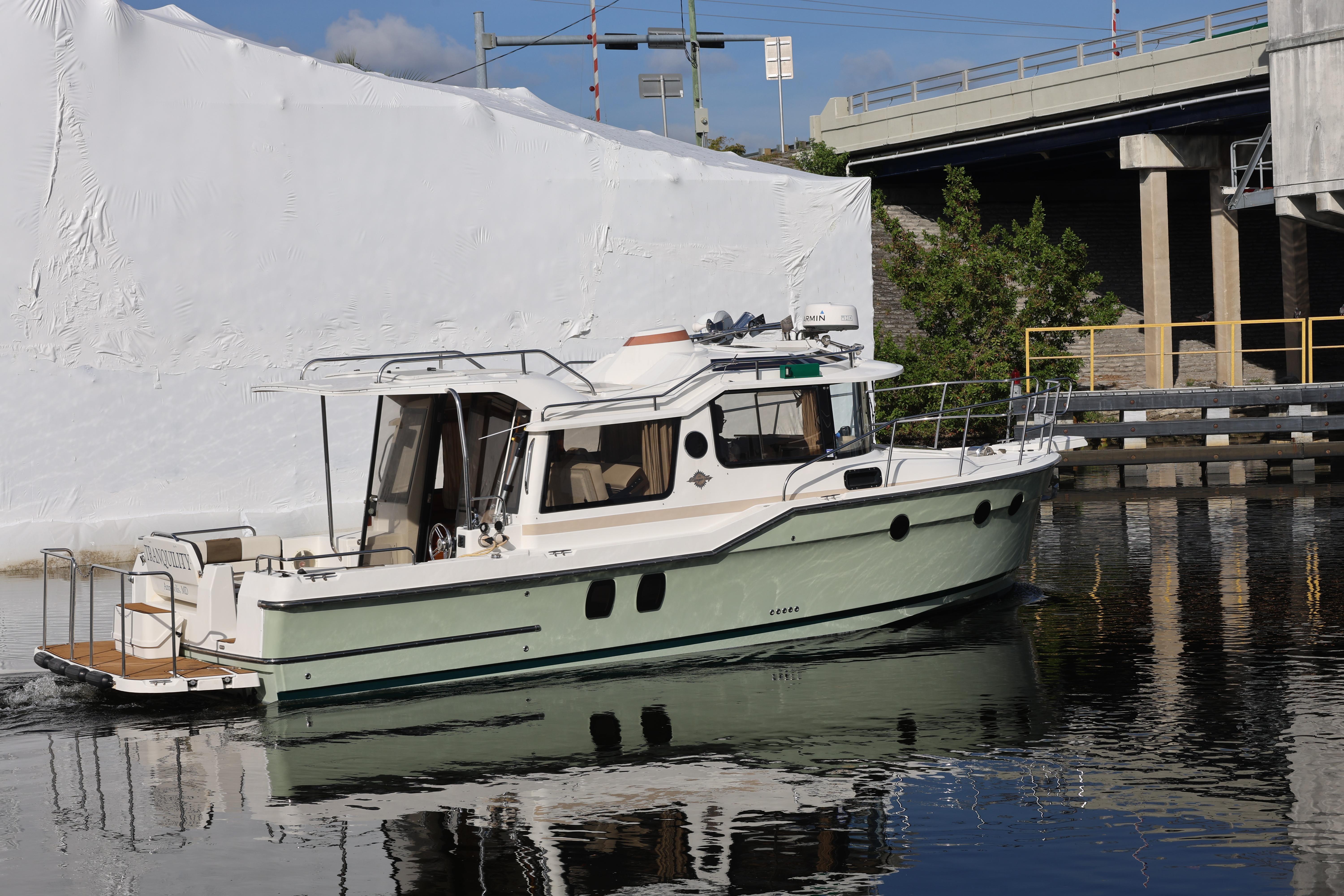 2015 Ranger Tugs R-29 S boat docked near a bridge on calm water.