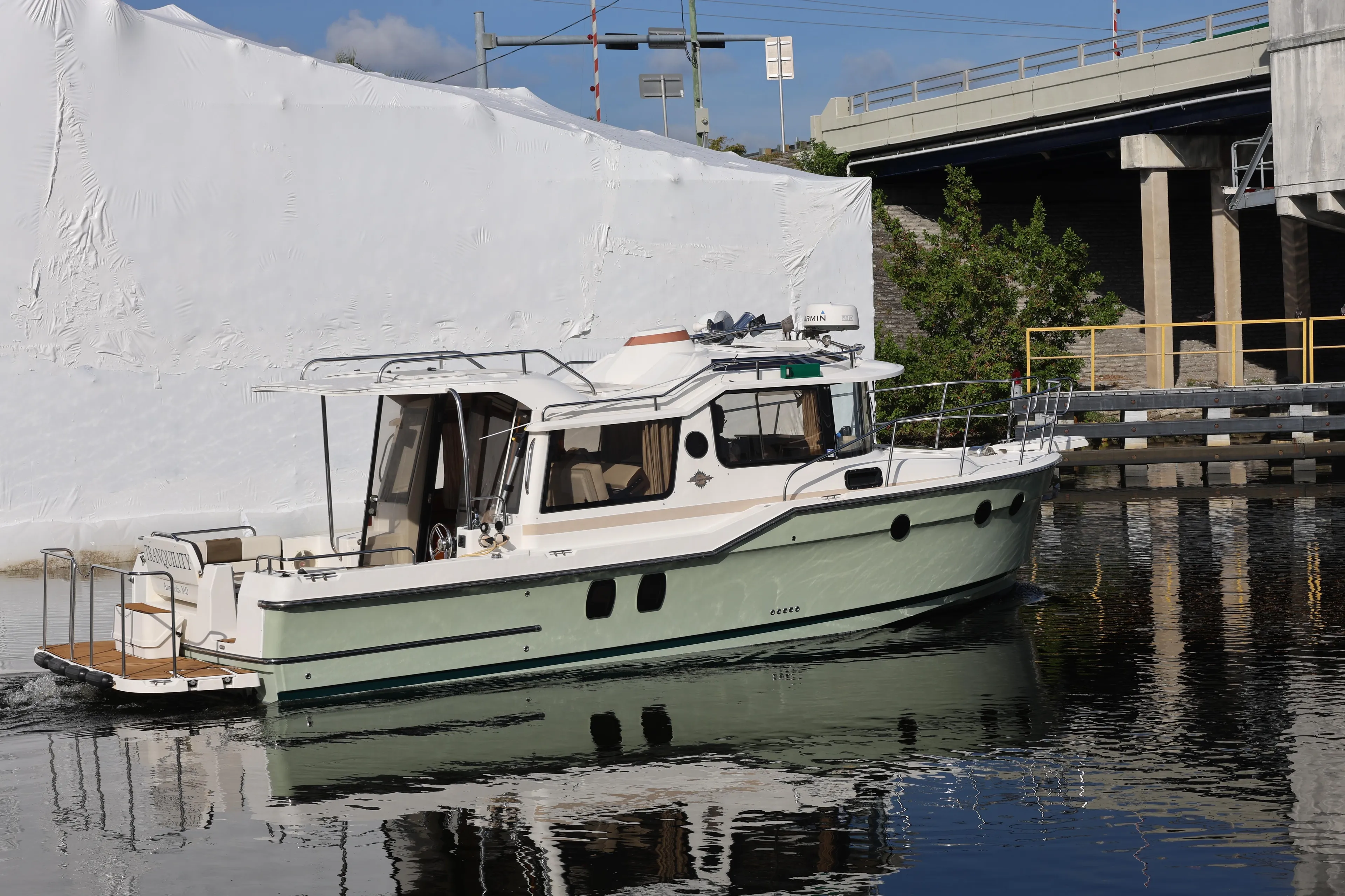 2015 Ranger Tugs R-29 S boat docked near a bridge on calm water.