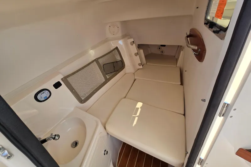  Yacht Photos Pics 2016 Grady-White Freedom 307 cabin interior with cushioned seating and compact sink.