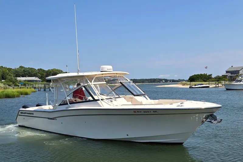  Yacht Photos Pics 2016 Grady-White Freedom 307 boat cruising on a sunny day in a scenic waterway.