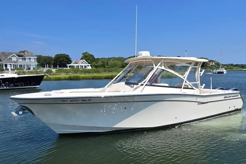  Yacht Photos Pics 2016 Grady-White Freedom 307 boat on calm water near shoreline homes.