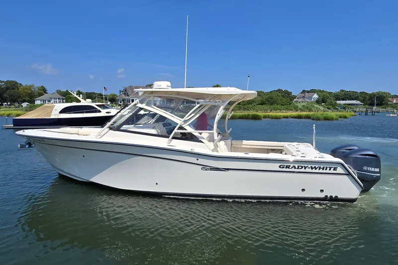  Yacht Photos Pics 2016 Grady-White Freedom 307 boat on calm water, clear sky background.