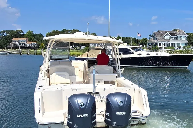  Yacht Photos Pics 2016 Grady-White Freedom 307 boat cruising in a scenic waterfront area.