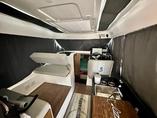  Yacht Photos Pics Interior of a 2019 Beneteau Antares 27 boat, featuring seating and kitchenette.