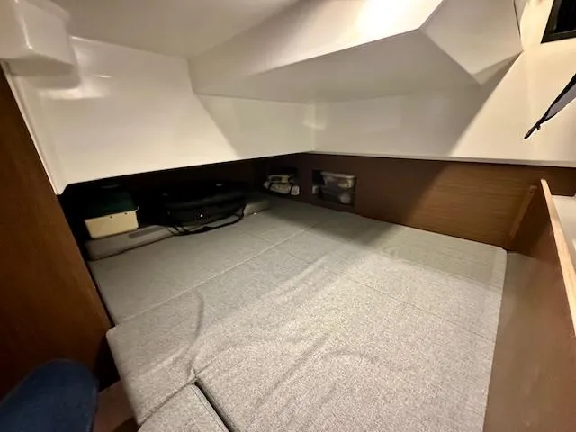  Yacht Photos Pics 2019 Beneteau Antares 27 cabin interior with gray bedding and wooden accents.