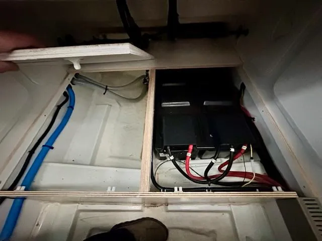  Yacht Photos Pics Battery compartment of a 2019 Beneteau Antares 27 boat, showing wiring and storage.