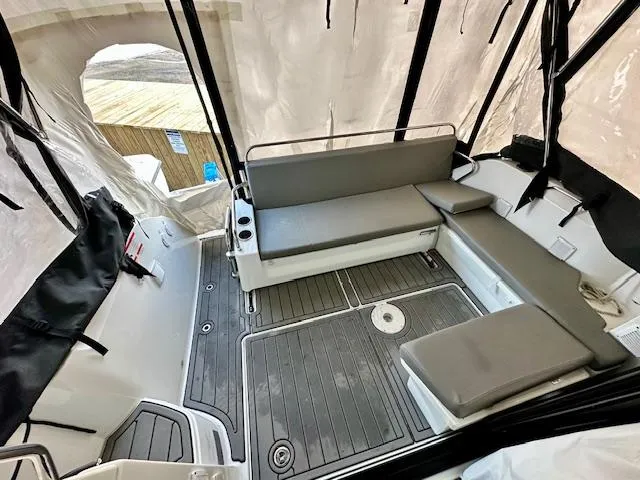  Yacht Photos Pics 2019 Beneteau Antares 27 boat interior with cushioned seating and protective cover.