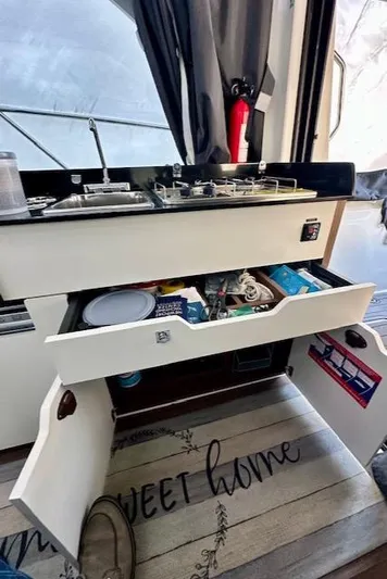  Yacht Photos Pics Interior of 2019 Beneteau Antares 27 showing kitchen storage and stove.