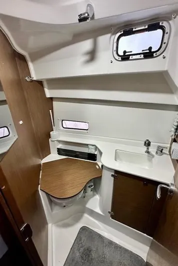  Yacht Photos Pics 2019 Beneteau Antares 27 boat interior with compact bathroom and wooden accents.