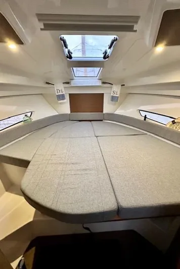  Yacht Photos Pics Interior cabin of a 2019 Beneteau Antares 27 with a spacious bed and skylight.