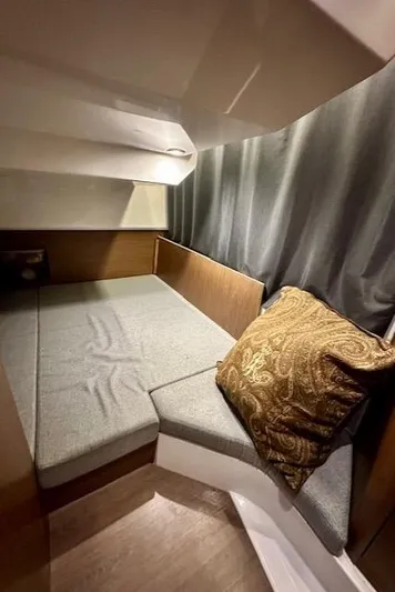  Yacht Photos Pics Cozy cabin interior of 2019 Beneteau Antares 27 with cushioned seating and decorative pillow.