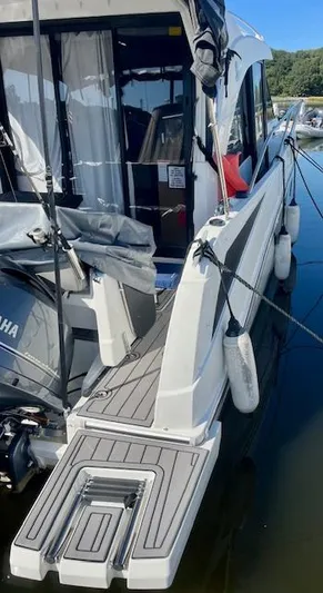  Yacht Photos Pics 2019 Beneteau Antares 27 docked, showcasing rear deck and motor, with fenders attached.