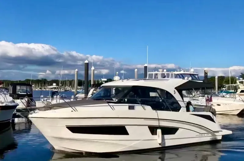  Yacht Photos Pics 2019 Beneteau Antares 27 boat docked in a marina under a clear blue sky.