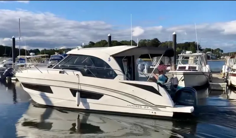  Yacht Photos Pics 2019 Beneteau Antares 27 boat docked in a marina, calm water, clear sky.