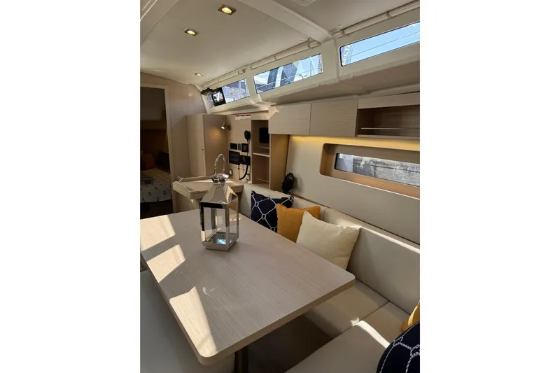 Show Boat! Special Pricing Yacht Photos Pics 2024 Beneteau Oceanis 37.1 interior with modern seating, table, and decorative pillows.