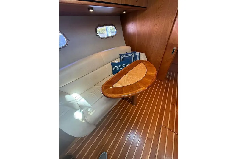 Ritz Karllton Too Yacht Photos Pics 2008 Tiara Yachts 3900 Sovran interior with elegant wood table and cushioned seating.