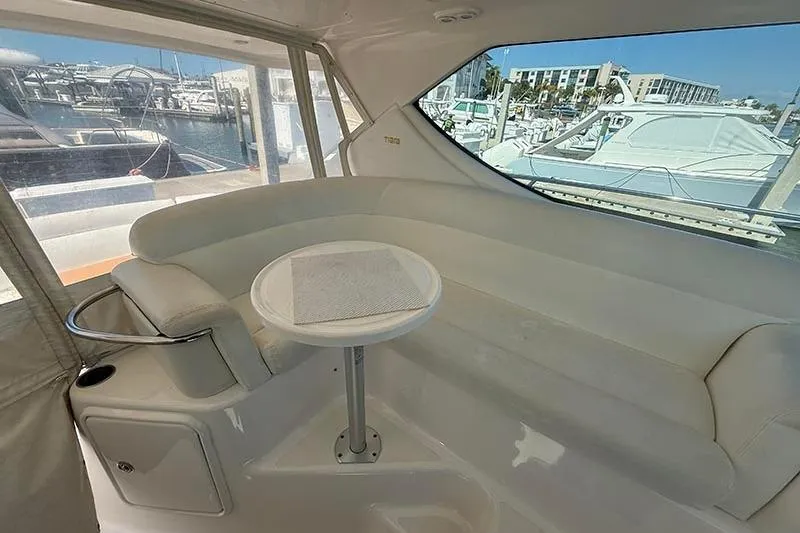 Ritz Karllton Too Yacht Photos Pics 2008 Tiara Yachts 3900 Sovran interior with white seating and small table, docked at marina.