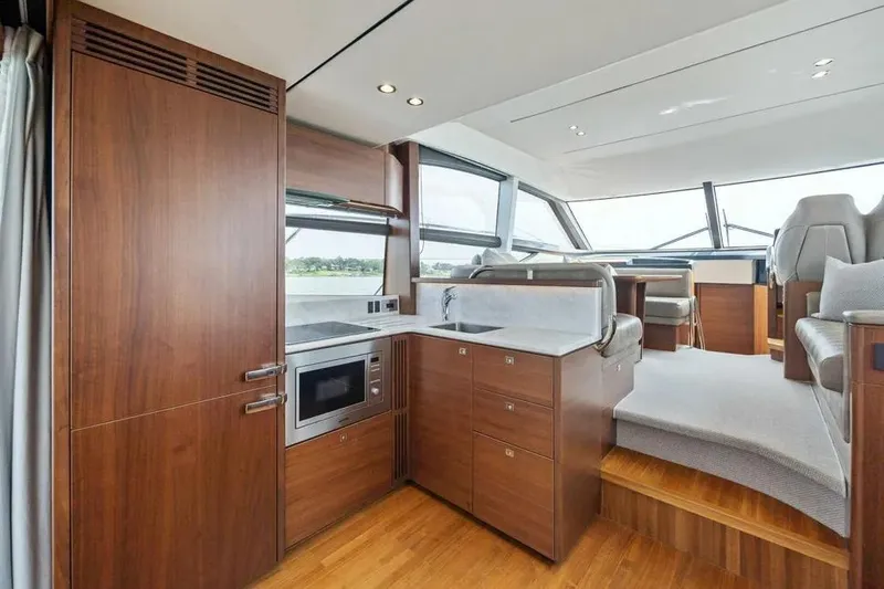  Yacht Photos Pics Luxurious interior of 2018 Princess F49 yacht with modern kitchen and seating area.