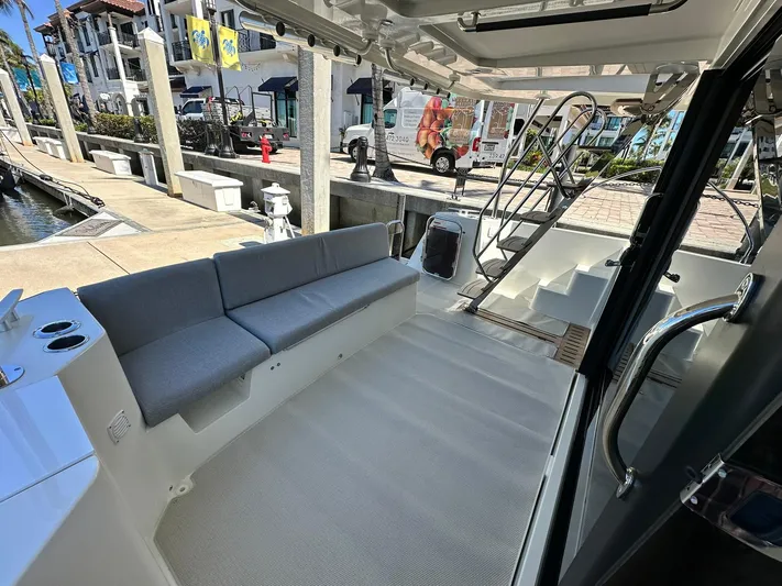 My Ty Yacht Photos Pics 2023 Beneteau Swift Trawler 48, spacious deck with seating, docked at marina.