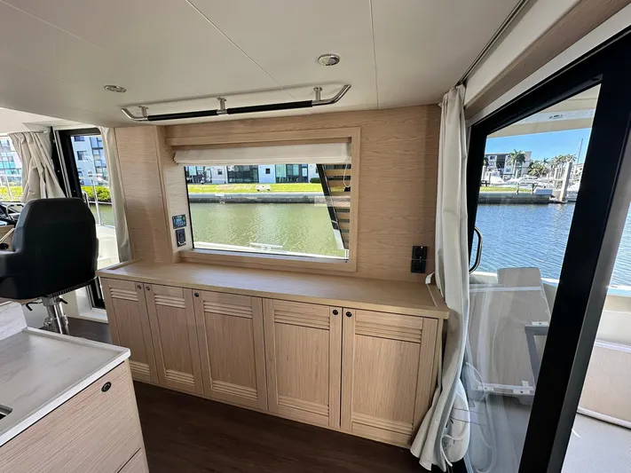 My Ty Yacht Photos Pics Interior of 2023 Beneteau Swift Trawler 48, featuring elegant wood cabinetry and large window view.