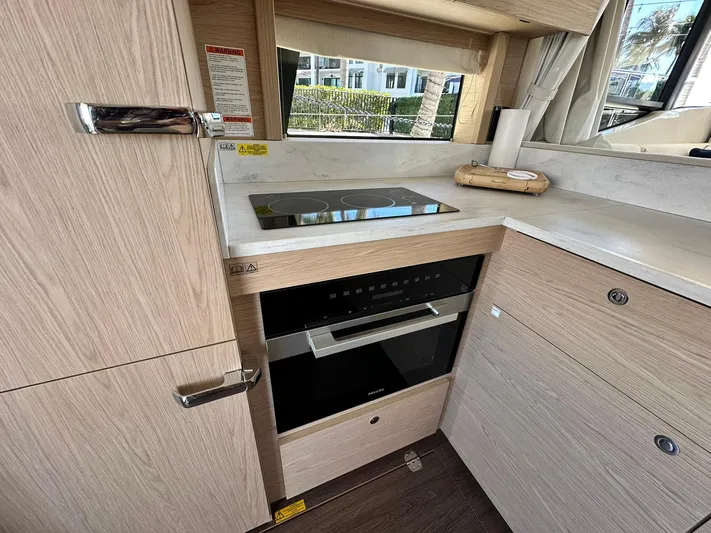 My Ty Yacht Photos Pics 2023 Beneteau Swift Trawler 48 kitchen with modern appliances and sleek cabinetry.