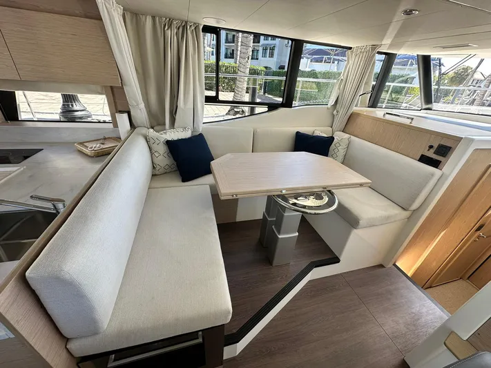 My Ty Yacht Photos Pics 2023 Beneteau Swift Trawler 48 interior with cozy seating and dining area.