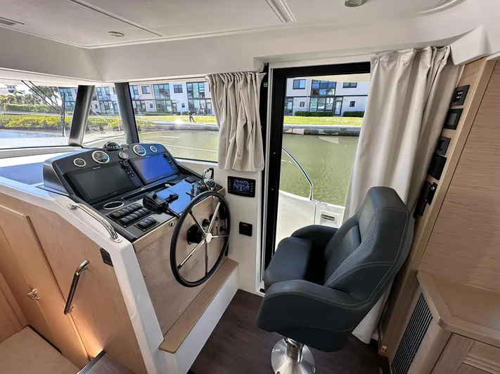 My Ty Yacht Photos Pics 2023 Beneteau Swift Trawler 48 helm station with modern controls and comfortable seating.