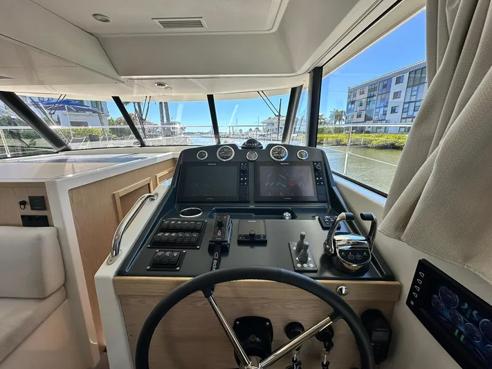 My Ty Yacht Photos Pics 2023 Beneteau Swift Trawler 48 helm with modern navigation equipment and panoramic windows.