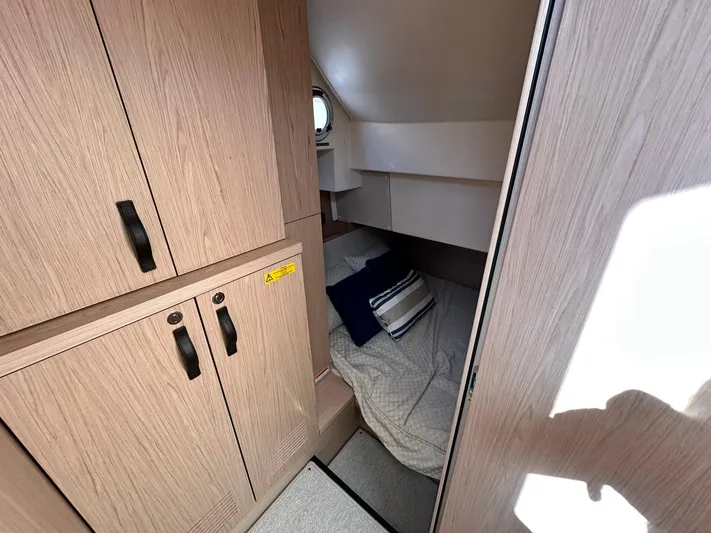 My Ty Yacht Photos Pics 2023 Beneteau Swift Trawler 48 cabin interior with wood finish and cozy bedding.