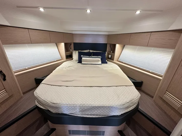 My Ty Yacht Photos Pics Luxurious bedroom interior of 2023 Beneteau Swift Trawler 48 with elegant bedding and ambient lighting.