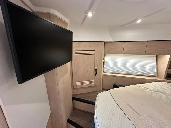 My Ty Yacht Photos Pics 2023 Beneteau Swift Trawler 48 interior cabin with TV and modern furnishings.