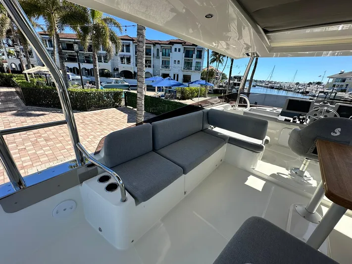 My Ty Yacht Photos Pics 2023 Beneteau Swift Trawler 48, spacious deck with seating, marina view in background.