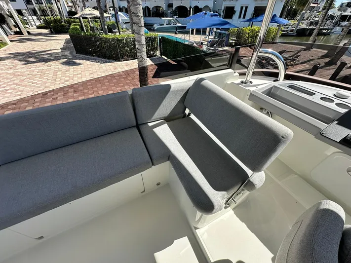 My Ty Yacht Photos Pics 2023 Beneteau Swift Trawler 48 seating area with gray cushions, dockside view.
