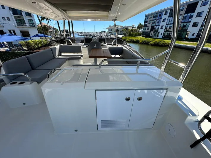 My Ty Yacht Photos Pics 2023 Beneteau Swift Trawler 48, spacious deck with seating and table, docked at marina.