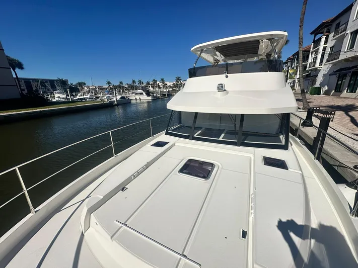 My Ty Yacht Photos Pics 2023 Beneteau Swift Trawler 48 docked at marina, sunny day, clear blue sky.
