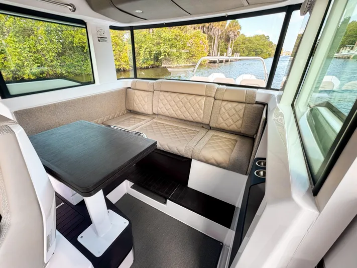  Yacht Photos Pics 2024 Axopar 37XC CROSS CABIN BRABUS Trim interior with seating and table, scenic water view.