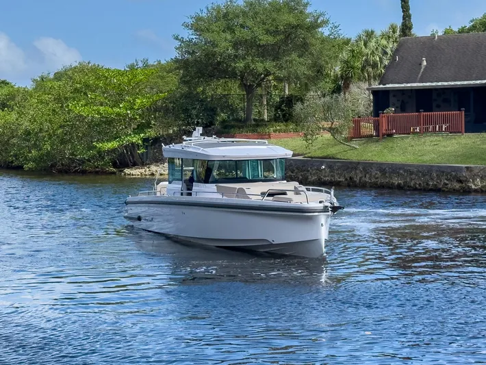  Yacht Photos Pics 2024 Axopar 37XC CROSS CABIN BRABUS Trim cruising on a serene waterway.