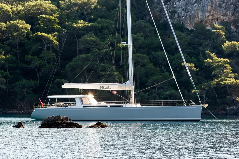 Mishi Yacht Photos Pics Sailing yacht "Mishi 88" anchored near a forested coastline, 2018 model.