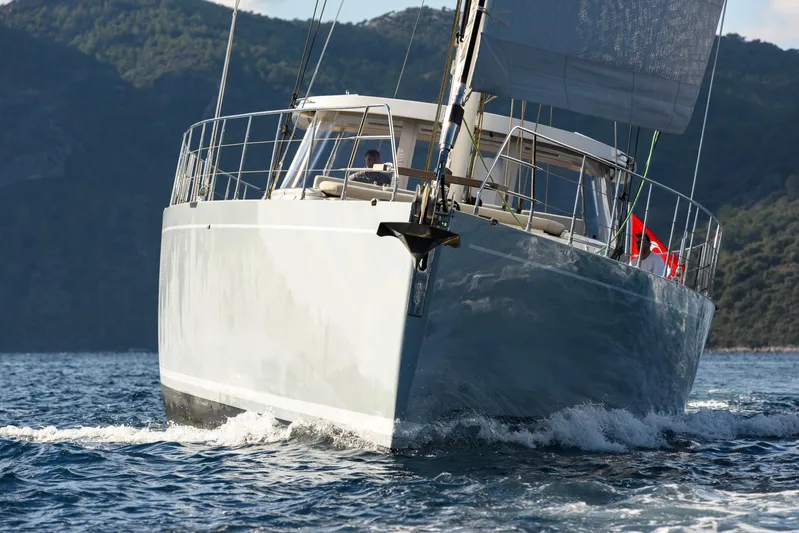 Mishi Yacht Photos Pics Sailing yacht "Mishi 88" cruising on open water, 2018 model, with scenic mountain backdrop.