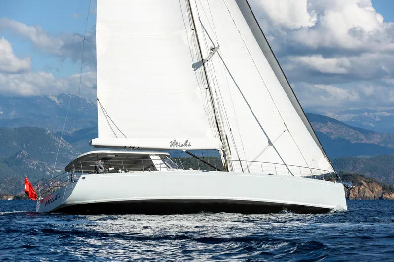 Mishi Yacht Photos Pics Sailing yacht "Mishi 88" gliding on the ocean, 2018 model, with scenic mountain backdrop.