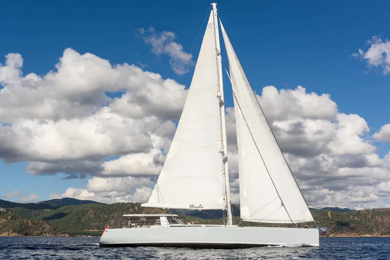 Mishi Yacht Photos Pics Sailing yacht "Mishi 88" gliding on water, under a partly cloudy sky, 2018 model.
