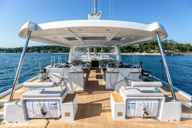 Mishi Yacht Photos Pics Luxurious 2018 Custom Mishi 88 yacht deck with dual steering wheels, docked by serene waters.